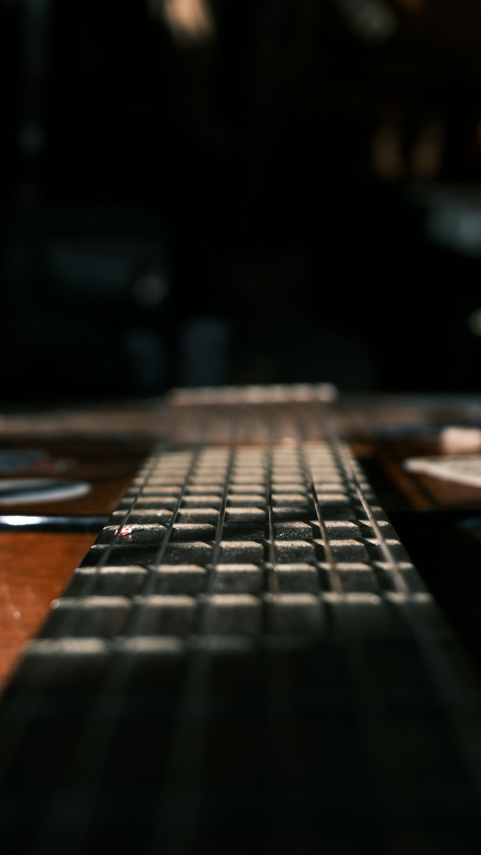 Loş ışıkta yakından bir gitar sapı ve telleri
